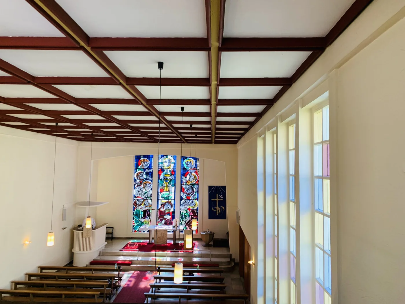 Kirchenraum mit Altar und Buntglasfenstern